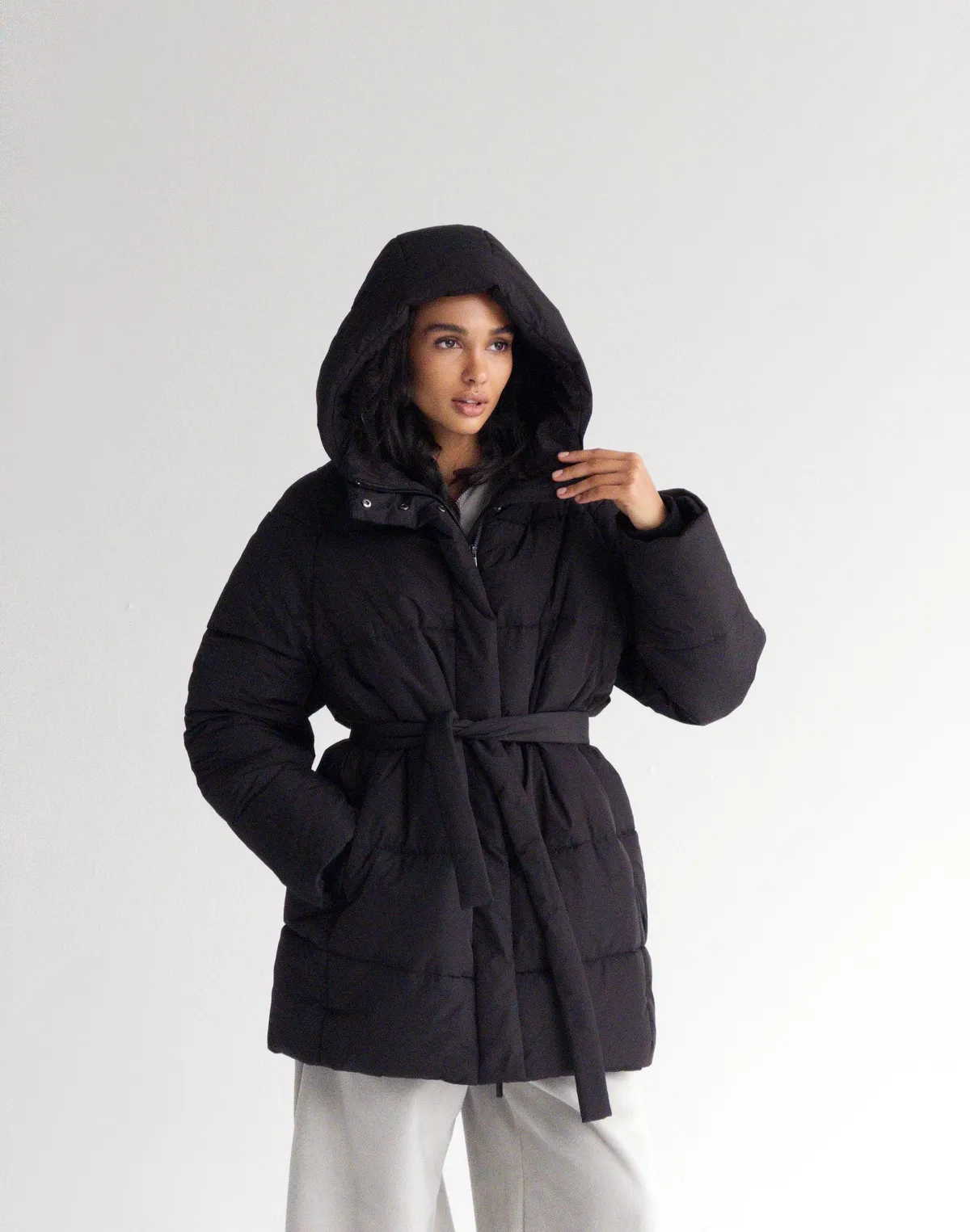 Куртка зимова середньої довжини з поясом та капюшоном, чорна - Фото 8
