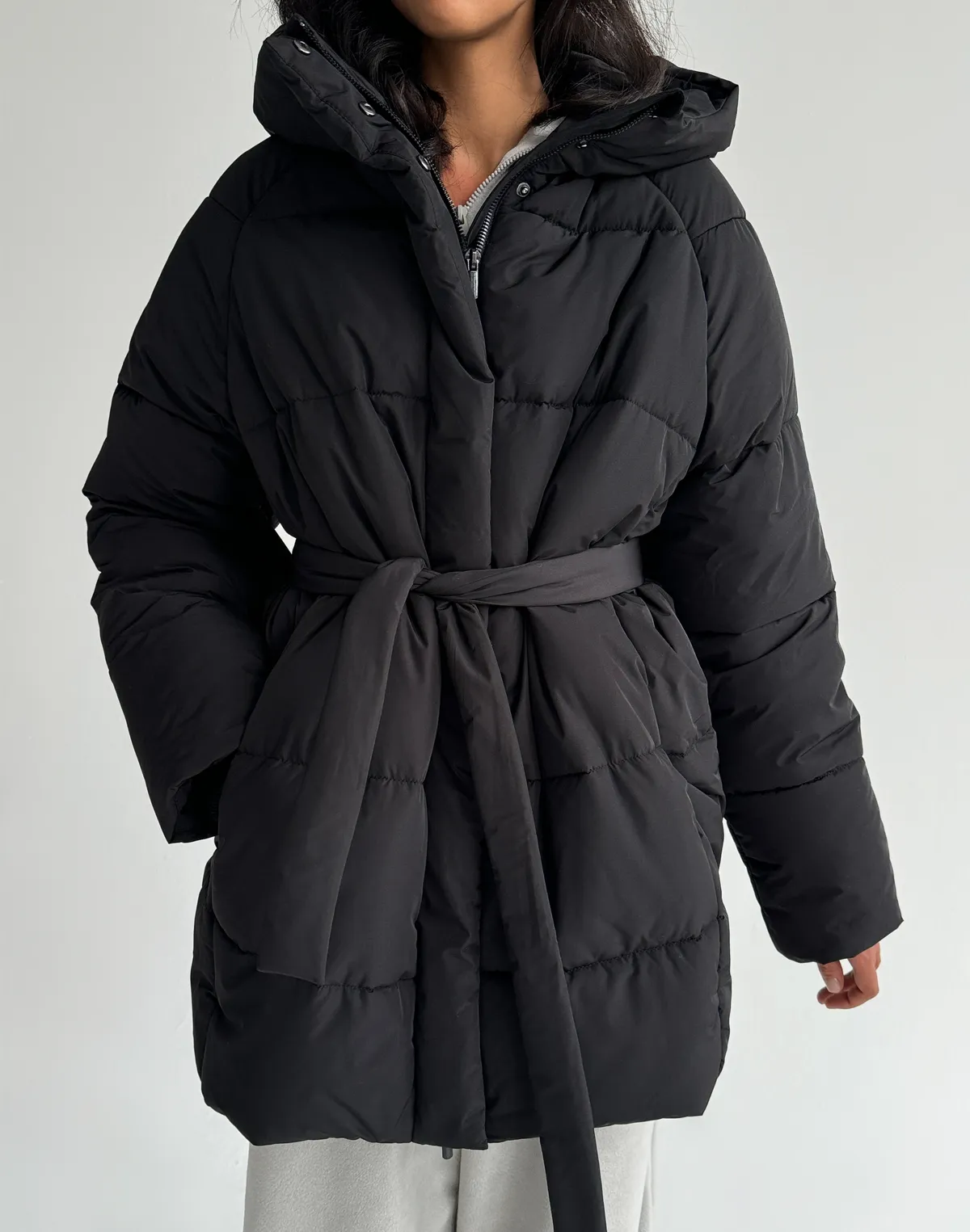 Куртка зимова середньої довжини з поясом та капюшоном, чорна - Фото 1